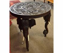 Eastern hardwood carved circular table with decorative carved top supported on three elephant carved
