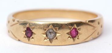 18ct stamped diamond and ruby ring, the centre a small diamond flanked by 2 small circular cut