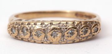 9ct gold small diamond ring, the seven small bezel set diamonds in an engraved and pierced gallery