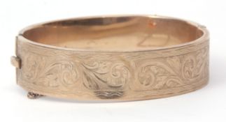 9ct gold hinged bracelet, part engraved with a scroll design, hallmarked Birmingham 1955, makers