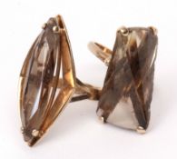 Two 9ct gold and smoky quartz designer rings, the lozenge shaped faceted stones claw set and