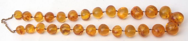 Vintage amber bead necklace, a single row of graduated beads, 8mm to 20mm, to a 9ct chain and ring