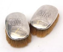 Two silver backed hair brushes each of polished oval form with contemporary initials and each