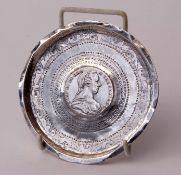 White metal circular ashtray with engraved concentric band detail centred with a Continental coin,