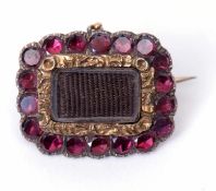 Antique Georgian mourning brooch having an amethyst paste surround with plaited hair panel circa