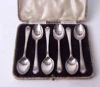 Cased set of six George V tea spoons, each with crossed golf club finials in silk and velvet lined