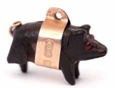 Vintage carved bog oak pig charm, set with two small cabochon red stone eyes, a gold band fitting,