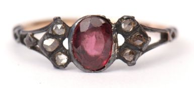 Antique garnet and diamond ring, the oval faceted garnet collet set and flanked either side with 3