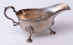 George V gravy boat of typical polished form with cast and applied rim and C-scroll handle on