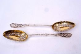 Pair of Victorian parcel gilt berry spoons with pierced and engraved handles to foliate embossed