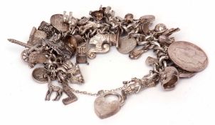 Heavy white metal curb link bracelet suspending various white metal charms including an