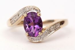 Modern amethyst and diamond cross-over ring, the central oval faceted amethyst joined by diamond