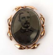 Early 20th century 9ct stamped photo/brooch, the oval shaped glazed panel within a polished leaf and