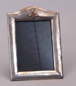 George V silver mounted easel backed photograph frame, the broad polished mount with shaped pediment