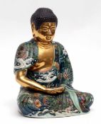 Oriental pottery model of a Buddha picked out in gilt with a green ground decoration with applied