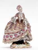 Continental porcelain Sevres type figure of a lady in flounced skirt on a scroll base, 23cms high