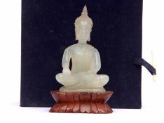 Mid/late 20th century small carved jadeite model of a seated goddess with carved treen stand, 9cms