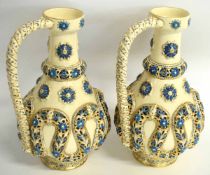 Pair of Continental reticulated faience ewers by Fischer Budapest (Zsolnay), decorated in relief