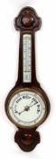 Early 20th century oak cased aneroid wheel barometer, the carved case set with a twin-scale