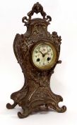 Early 20th century French base metal cased mantel clock, the waisted case with applied floral and