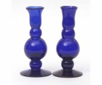Pair of blue glass candlesticks of lobed baluster form terminating in spreading circular bases,