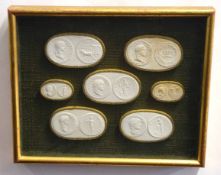 Collection of pottery plaques of Roman coins in a display case, 27cms long