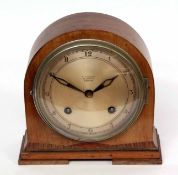 Mid-20th century walnut and inlaid mantel clock, the arched case on bracket feet to a chrome