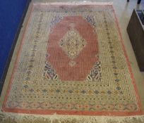 Modern Persian type carpet with a puce centre and cream multi-gulled border, with central diamond