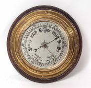 Late 19th century brass cased aneroid barometer with moulded surround to a shaped and stepped