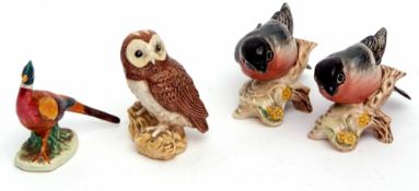 A Beswick model of a pheasant, two Bullfinches, and a further model of an owl (4)