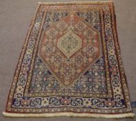 Caucasian wool rug, two graduated central lozenges, mainly rust and blue field within a triple-