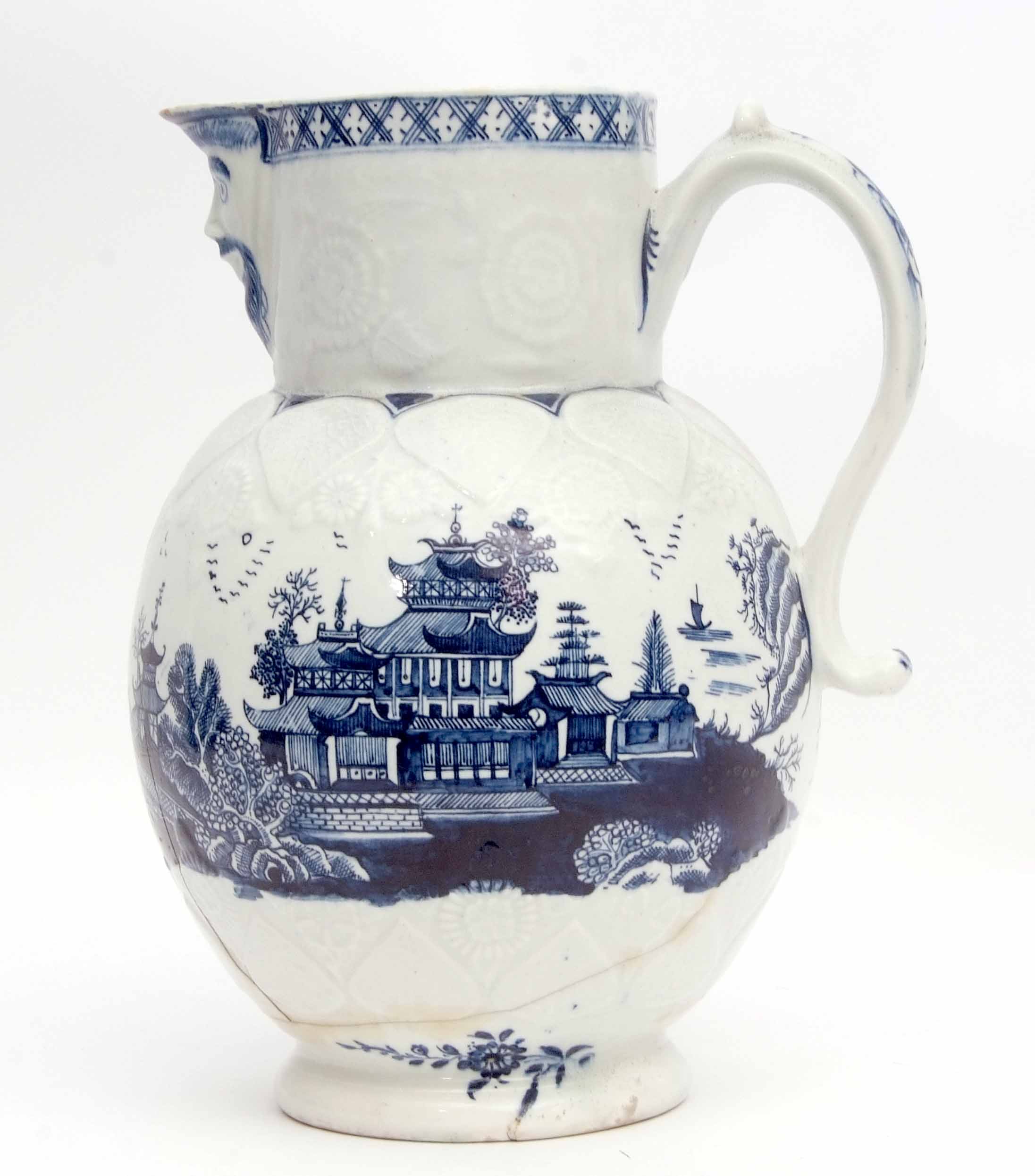 Rare Lowestoft mask jug, the moulded body decorated with pagodas and Chinese island scenes, the