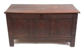 Late 17th/early 18th century oak coffer, plain plank top over a three-panelled front carved with