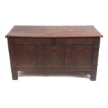 Late 17th/early 18th century oak coffer, plain plank top over a three-panelled front carved with