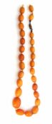 Vintage amber bead necklace, a single row of graduated beads, 15mm to 25mm, to a metal barrel