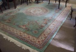 Large Indian or Chinese thick pile wool carpet, typically decorated on a pale blue green field,