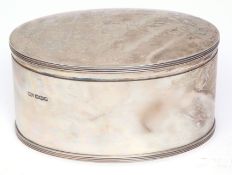 George V oval canister of plain and polished form with initialled cover and reeded rims, width 17cm,
