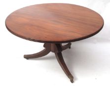 Regency period mahogany circular dining table, with reeded edge, raised on lobed baluster support