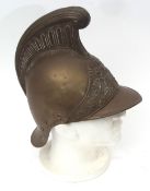 Early 20th century French fireman's helmet with scrolling crest and applied badge with crossed