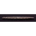 Art Deco precious metal diamond brooch, the pierced elongated plaque, set with a principal collet