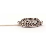 Art Deco precious metal and diamond tie-pin, the oval shaped pierced panel decorated throughout with