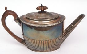 George III oval tea pot of half-fluted form with hinged and domed cover and treen handle and finial,