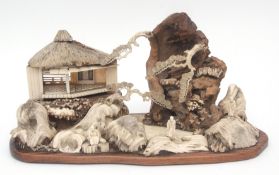 Intricate Japanese diorama depicting a mountainous landscape with pavilions and figures in wood,