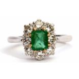 Emerald and diamond cluster ring featuring a rectangular step cut emerald, claw set and raised