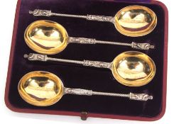 Cased set of four "Apostle" type parcel gilt serving spoons, each with polished oval blades and gilt