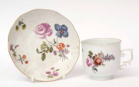 Mid-18th century Meissen coffee cup and saucer, the cup with Tau handle decorated with floral sprays