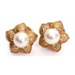 Pair of 18ct gold pearl and diamond flower head rings featuring a central cultured pearl raised