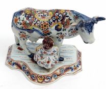 Dutch Delft milkmaid group, probably 19th century, modelled as a maid milking a cow, decorated in