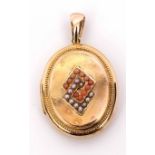 Antique yellow metal oval locket, the centre applied with two overlapping geometric shapes, one