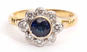 18ct gold, sapphire and diamond cluster ring, the circular shaped faceted sapphire collet set within